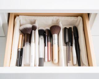 Ordentlich aufbewahrte Beauty-Tools in einer hellen Schublade mit Stoffeinsatz